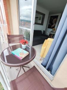 a table with a book on it on a balcony at Faro 2 Loft Jaime Duque, Autódromo Tocancipá in Tocancipá