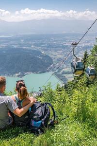 two people sitting on top of a hill with a ski lift at Lakeside Garden Ossiacher See in Sattendorf