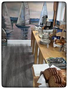 a kitchen with a table with some bread and sailboats at Britmead Guesthouse in West Bay +19 photos