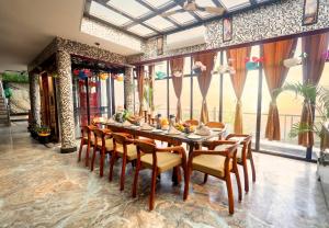 a dining room with a long table and chairs at Aman Homestay, A Boutique Hotel in Agra