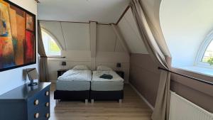 a small bedroom with two beds in a attic at Holiday Beach House Hellevoetsluis in Hellevoetsluis