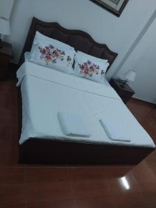a bed with two pillows on top of it at Studio Apartment in Abḩur al Janūbīyah