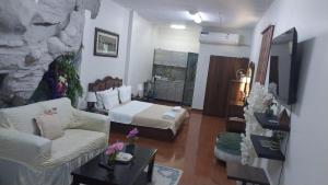 a living room with a couch and a bed at Studio Apartment in Abḩur al Janūbīyah