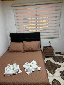 a bed with towels on top of it with a window at Apartamentos Paipa Boyacá "Las Quintas" Pisos 2 y 3 in Paipa