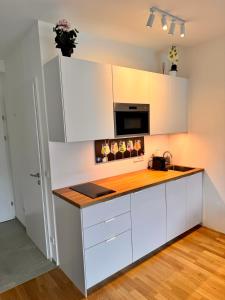 a kitchen with white cabinets and a wooden counter top at Lakeside Garden Ossiacher See in Sattendorf