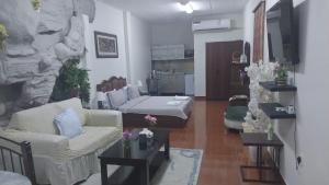 a living room with a couch and a bed at Studio Apartment in Abḩur al Janūbīyah +1 photo