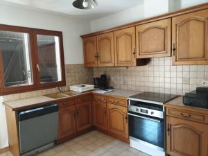 a kitchen with wooden cabinets and a sink and stove at Maison 80 m2 - proche des plages in Montpellier +3 photos