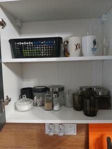 a shelf with a bunch of pots and pans at Marshal Foch Apartment in Grudziądz +15 photos