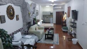 a living room with a couch and a stone wall at Studio Apartment in Abḩur al Janūbīyah