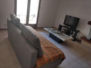 a living room with a couch and a tv at Maison 80 m2 - proche des plages in Montpellier