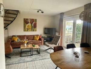 a living room with a couch and a table at Holiday Beach House Hellevoetsluis in Hellevoetsluis