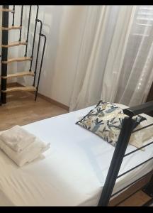 a bed with white sheets and a pillow on it at Triplex Hyper Centre Bastia Direct Musée et Citadelle in Bastia