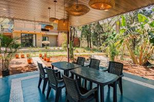 a patio with a table and chairs and a garden at The Marigold Villa in Pune