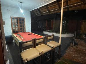 a ping pong table and two chairs in a room at Mafofolozi Lodge in Hartbeespoort