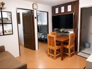 a living room with a table and chairs and a television at Joi's One Oasis Condo Near Limketkai Mall in Cagayan de Oro