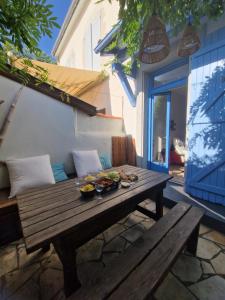 a wooden table with bowls of food on a patio at COTTAGE - Utopy Hostel in Capbreton