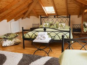 a bedroom with a black bed in a room with wooden ceilings at Filyra Pension in Nafplio