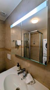 a bathroom with a sink and a large mirror at Chillon lake view by MK in Montreux +14 photos