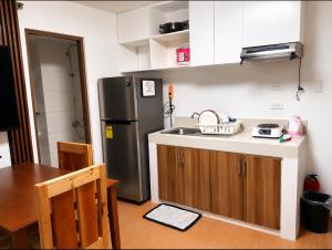 a kitchen with a sink and a refrigerator at Joi's One Oasis Condo Near Limketkai Mall in Cagayan de Oro