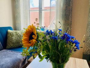 a vase of flowers on a table next to a window at Kauba 6-6 Apartment in Kuressaare +11 photos