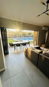 a living room with a couch and a table with chairs at CELONIA VILLA - Euphoria Golf Estate in Naboomspruit