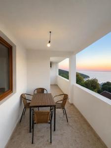 a balcony with a table and chairs and a view of the ocean at Darinka in Ulcinj