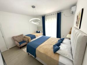 a bedroom with a bed and a chair in it at Apartmani Avanti Becici in Bečići +100 photos