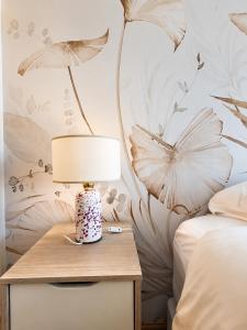 ein Schlafzimmer mit einem Tisch, auf dem eine Lampe steht in der Unterkunft AC Suites in Puerto Madryn