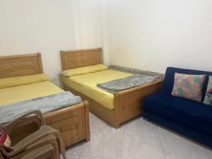 a room with two beds and a blue chair at White Bay Ras Sedr وايت باي راس سدر in Ras Sedr