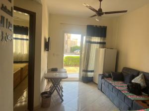 a living room with a blue couch and a window at White Bay Ras Sedr وايت باي راس سدر in Ras Sedr