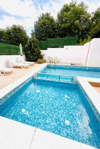 a swimming pool with blue water in a backyard at Byla Central Studio in Byala