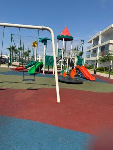 a playground with slides and a swing at Escapade à Sidi Rahal in Sidi Rahal