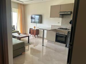 a kitchen and living room with a couch and a table at Escapade à Sidi Rahal in Sidi Rahal