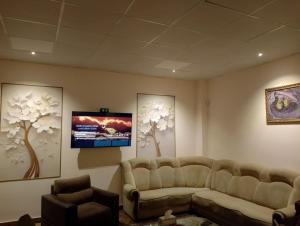 a waiting room with a couch and a flat screen tv at Tsaghkadzor Family Rest in Tsaghkadzor +3 photos