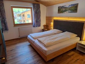 a bedroom with a bed and a window at Appartment Sonnenkogel in Holzgau
