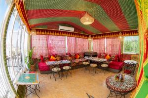 a living room with a couch and tables and windows at Dar Amireal Fez in Fez