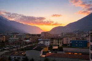 a sunset over a city with mountains in the background at Civico27-modern apartment in Sondrio in Sondrio