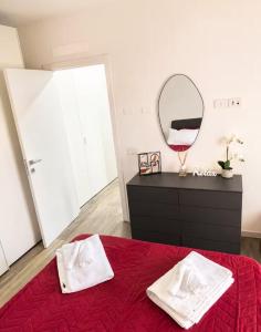 a bedroom with a red bed and a mirror at Civico27-modern apartment in Sondrio in Sondrio