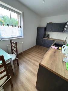 a kitchen with a desk and a table with chairs at Monteuerwohnung in ruhiger Lage in Möser