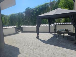 a gazebo with a table and chairs on a patio at Apartman Soko 2 in Soko Banja +18 photos