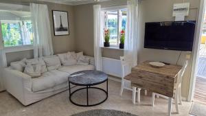 a living room with a white couch and a table at Semesterbostad Viksberg in Avesta +7 photos