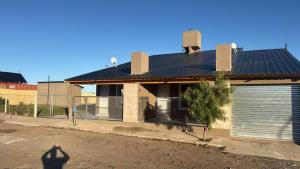 a house with a metal roof and a garage at Duplex 1 en villa el chocon LO DE CARLITOS in Villa El Chocón