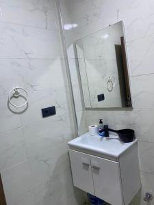 a bathroom with a sink and a shower with a mirror at Appartement 2 chambres Martil in Martil