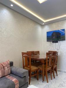 a dining room with a table and chairs and a couch at Appartement 2 chambres Martil in Martil