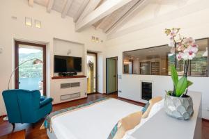 a living room with a large bed and a blue chair at Luxury Como Lake - Luxury Villa with Infinity Pool in Blevio
