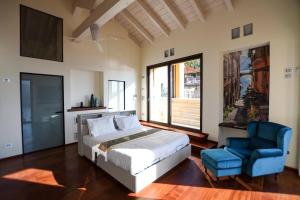 a bedroom with a bed and a blue chair at Luxury Como Lake - Luxury Villa with Infinity Pool in Blevio +67 photos