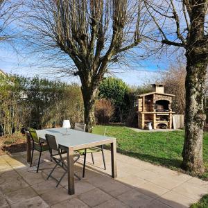 a table and chairs on a patio in a garden at le Studio Balnéo des Cocons de Mel in Quinssaines