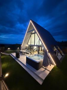 a large glass house with a hot tub on a roof at LUMA Lodge in Sadu