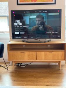 a flat screen tv sitting on a wooden stand at Blackfriars Cosy Retreat in Glasgow