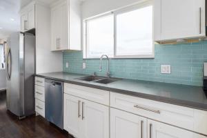 a kitchen with white cabinets and a stainless steel refrigerator at SF City Inn free parking on site in Oakland +4 photos